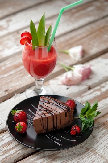 chocolate cake beside strawberries and wine glass