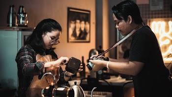 Cinematographer filming a woman making coffee