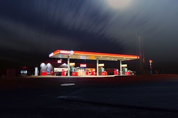 Circle gas station along the road during night time