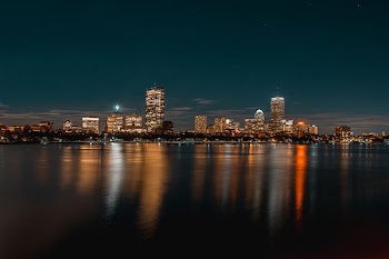 city buildings next to body of water during nighttime
