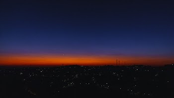 City Under Orange Sky at Night Time
