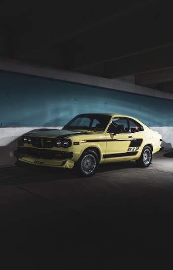 Classic Yellow Coupe Parked Next to Wall