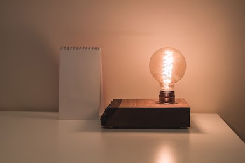 Clear Bulb Beside White Notepad on White Surface · Free Stock Photo