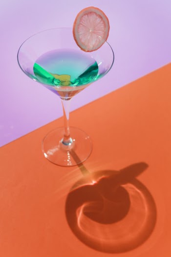 Clear Cocktail Glass On Orange Surface