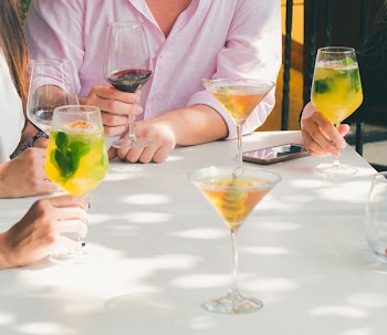 Clear Cocktail Glass on Top of White Wooden Table