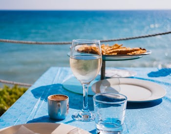 Clear Drinking Glass Beside Plate on Table Far from Water Close-up Photography