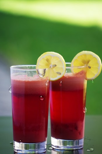 Clear Drinking Glass Filled With Red Liquid With Sliced Lemon