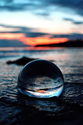 Clear Glass Ball on Shore in Tilt Shift Lens Photo