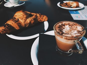 Clear Glass Cup Filled With Cappuccino Beside Croissant Bread