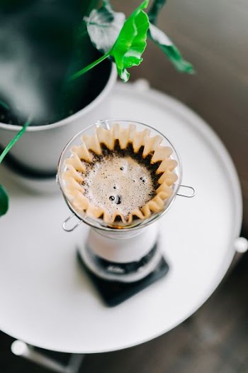 clear glass drinking cup and saucer