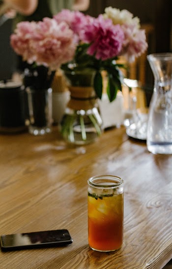 Clear Glass Jar on Table Beside Phone
