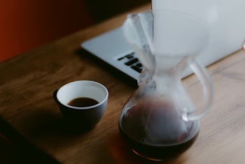 Clear Glass Pitcher Beside Black Ceramic Teacup