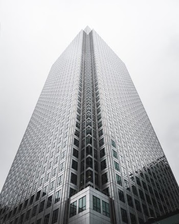 clear glass skyscaper under white sky