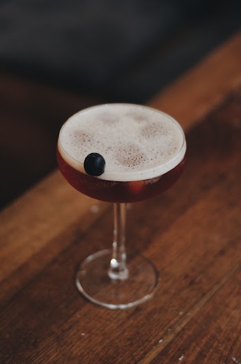 Clear Martini Glass Filled with a Drink on a Brown Wooden Surface