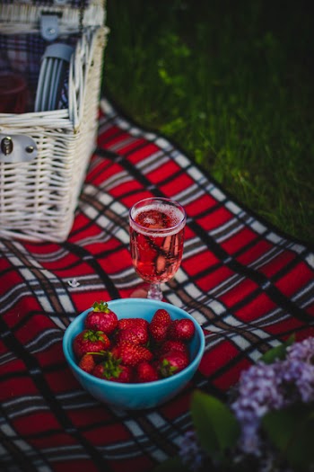 Clear Wine Glass With Wine Near Strawberry Fruit on Red White and Black Plaid Textile