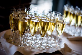 Clear Wine Glasses with Gold Liquid on White Cloth Covered Table