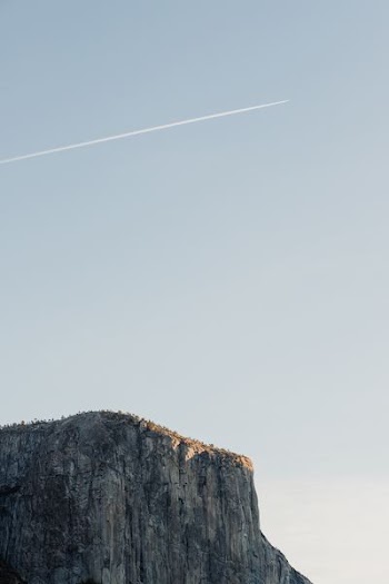 cliff under cloudy sky during daytime