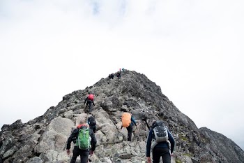 climbers hiking through mountain peak during daytime