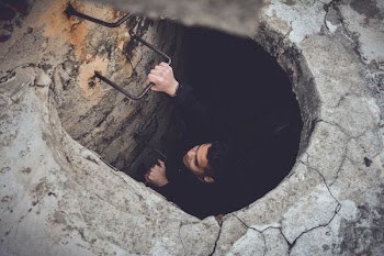 Climbing up a metal wire ladder in a concrete tunnel