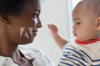 Close up affectionate mother holding baby son