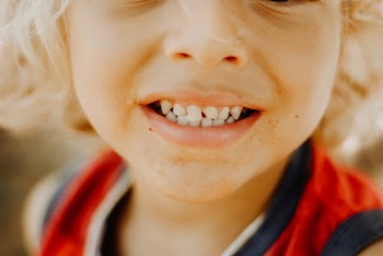 Close-up Child Wearing Red and Black Tank Top Smiling