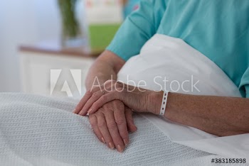 Close up hands of female senior patient in hospital bed