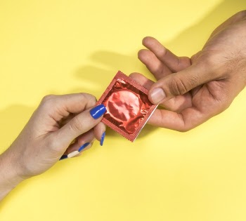 Close-up man and woman holding a condom Free Photo
