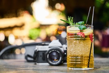 Close-up Of A Cocktail Drink Near Slr Camera