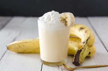 Close-up of banana smoothie with golden spoon Free Photo