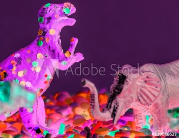 Close up of dinosaurs and animal figure toys on sweet candy sprinkles