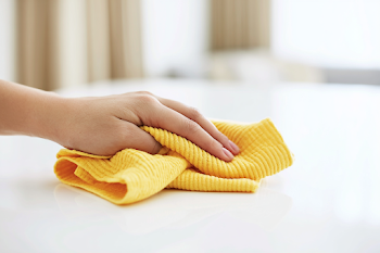 Close-Up of Hand Cleaning a White Tabletop