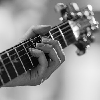 Close-Up of Hand Playing Guitar Strings