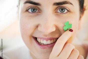 close up of happy young woman face with shamrock