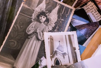 Close-up Of Old Black and White Photos Of A Young Girl In An Angel Costume And A Church