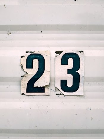 Close-up Of  The Number 23 Sticker On A White Corrugated Surface