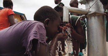 Close-up Of Two Children Drinking Water on Water Pump