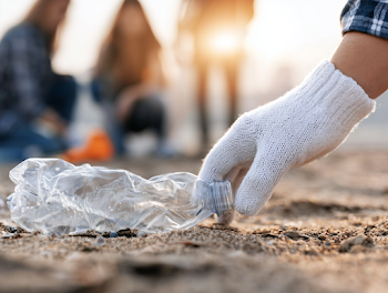 Close-Up of Volunteer Picking Up Plastic Waste on Beach