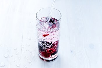 Close-up of Water Splashing in Glass Against White Background