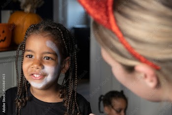 Close-up of woman and sons face with white paint on face for Halloween