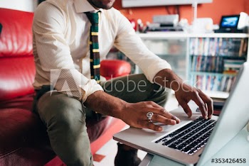 Close up of young businessman working on laptop at home