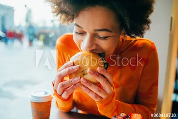 Close up of young woman eating hamburger
