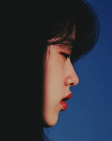 Close-Up of Young Woman's Upset Expression Against Blue Sky Background Close-Up of Young Woman's Upset Expression Against Blue Sky Background
