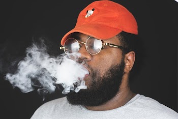 Close-Up Photo of a Man Breathing Smoke