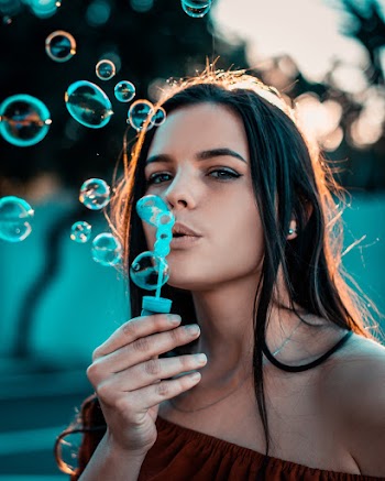 Close-Up Photo of a Woman Blowing Bubbles