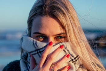 Close-Up Photo of a Woman Covering Her Face With Scarf