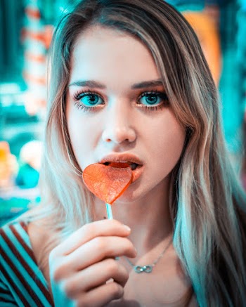 Close-Up Photo of a Woman Eating Lollipop