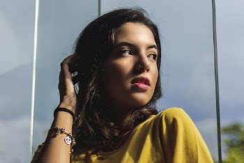 Close-up Photo of a Woman Posing in Front of a Window