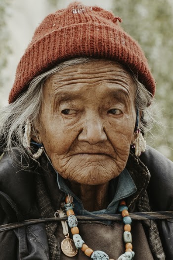 Close-Up Photo of an Old Woman Wearing Red Knit Cap