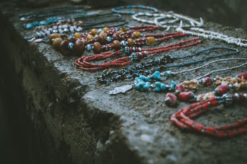 Close Up Photo of Beaded Accessories on Gray Surface
