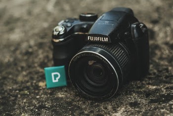 Close-up Photo of Black Fujifilm Dsrl Camera on the Ground